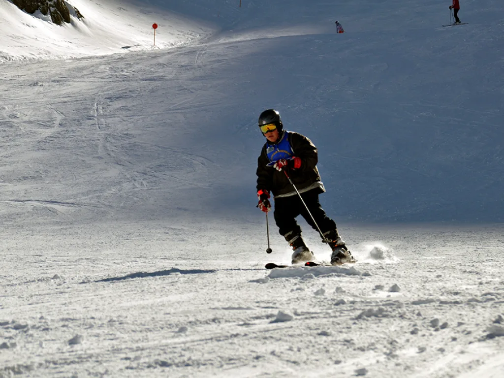 Skifahrer zieht einen Schwung auf der freien Piste.